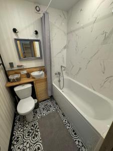 a bathroom with a tub and a toilet and a sink at New apartment in JYSK style in Cherkasy