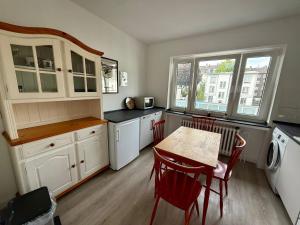 a kitchen with white cabinets and a table and chairs at Wu Stay in Wuppertal