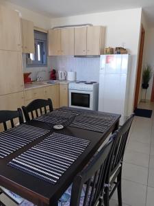a kitchen with a table with chairs and a refrigerator at Poly's house in Loutsa