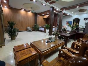 a waiting room with wooden tables and chairs at Đá Gió Hà Giang Homestay in Ha Giang