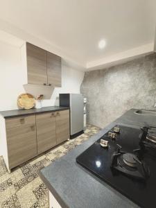 タオ島にあるApartment Villa Marのキッチン(黒いカウンタートップ、冷蔵庫付)