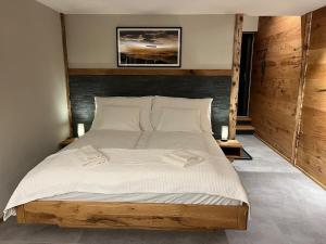 a bedroom with a large bed with white sheets at Mountain Homes -Base Camp Studio in Bönigen