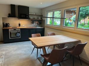 a kitchen with a wooden table and chairs at Mountain Homes -Base Camp Studio in Bönigen +13 photos