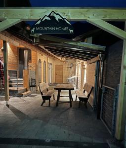 a picnic table and two benches on a patio at Mountain Homes -Base Camp Studio in Bönigen