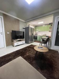 a kitchen with green cabinets and a table and a refrigerator at Sweet Home villa in Tirana
