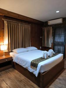 a bedroom with a large bed with towels on it at Orchid Resort in Lat Krabang