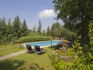 a yard with a swimming pool and some chairs at Pretty farmhouse with terrace in Radda in Chianti