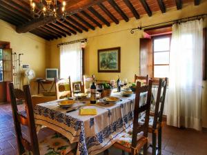 a dining room with a table with chairs and a tableablish at Pretty farmhouse with terrace in Radda in Chianti