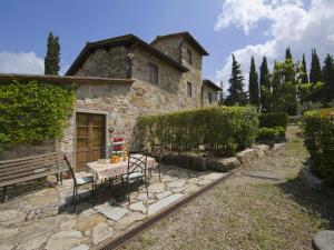 a stone house with a table and a bench at Pretty farmhouse with terrace in Radda in Chianti +32 photos