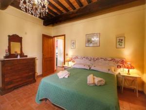 a bedroom with a bed and a dresser and a mirror at Pretty farmhouse with terrace in Radda in Chianti