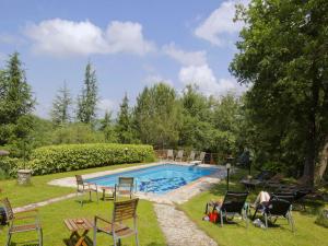 a pool with a bunch of chairs around it at Pretty farmhouse with terrace in Radda in Chianti