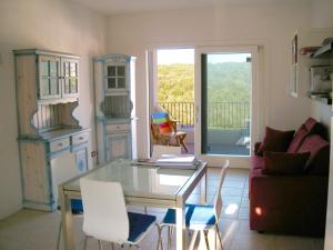 a living room with a glass table and white chairs at elegant apartment near the beach of Baja Sardinia in Baraccamenti