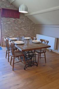 - une table en bois avec des chaises, des assiettes et des verres dans l'établissement Den Dilte, à Jabbeke