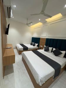 a hotel room with two beds and a television at Hotel Divya Regency in Jāmb