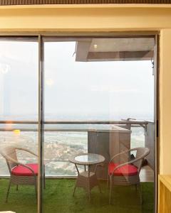 a room with a table and chairs and a large window at Elite Comfort Stay in Noida