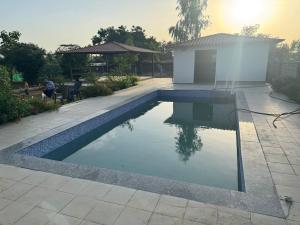 a swimming pool in a yard with a building at FF Family Farm in Hyderabad