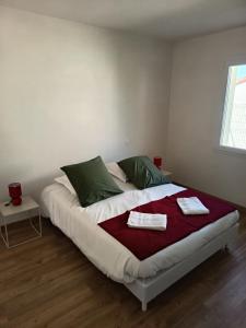 a bedroom with a large bed with two towels on it at Maison 2 ch-6 pers parking & jardin in La Pommeraie-sur-Sèvre