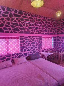 a purple bedroom with a bed and a purple wall at Pink House Vattakanal Kodaikanal in Kodaikānāl
