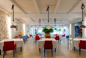 a restaurant with white tables and red chairs at Masseria Mancini in Polignano a Mare