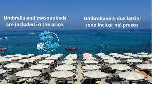 a bunch of umbrellas on a beach with the ocean at Don Peppe Rooms With Beach Service Included in Tropea
