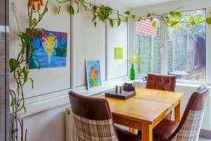 a dining room with a wooden table and chairs at Stunning Family Home nr London Harry Potter Tour Pass The Keys in Borehamwood