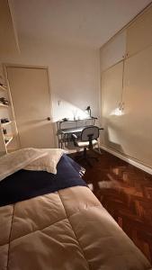 a bedroom with a bed and a desk in it at Descanso y trabajo con jardín en Barrio Carrasco in Montevideo
