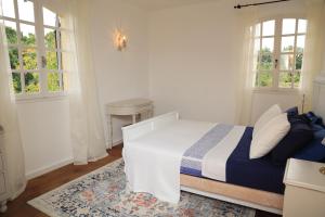 una camera da letto con un letto, un tavolo e finestre di Pure Gardères a Monlezun Altre 139 foto