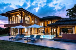 a house with a pool and some chairs and umbrellas at VILLA DIVA STAR in Ko Yao Noi