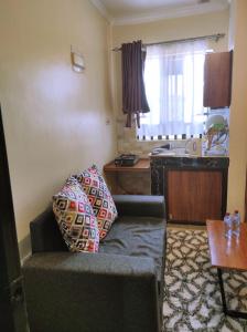 a living room with a couch and a kitchen at Lakeview Studios in Kisumu