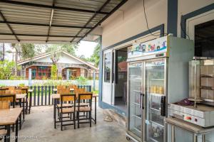 a restaurant with tables and chairs and a refrigerator at Relax home in Ao Nang 