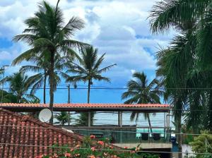 vistas al océano con palmeras y a un edificio en Marmeu Tropical (Com garagem), en Guarujá