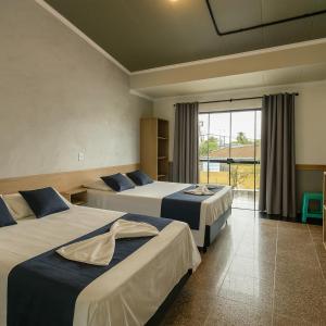 Una habitación de hotel con dos camas y balcón. en Marmeu Tropical (Com garagem), en Guarujá 11 fotos más