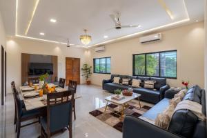 a living room with a couch and a table at The Fernstead Hillview 5-BHK Villa With Private Pool & Terrace Near Major Beaches in Parhūr