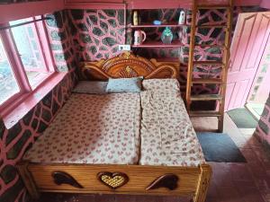 a wooden bed in a room with two hearts on it at Pink House Vattakanal Kodaikanal in Kodaikānāl +4 photos