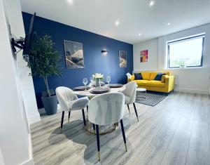 a living room with a table and chairs and a yellow couch at Luxury Norwich City Centre Flat - Free Parking in Norwich