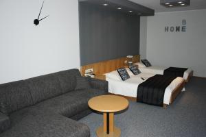 a room with a couch and a bed and a table at Hotel & Appartementen Royal in Sas van Gent