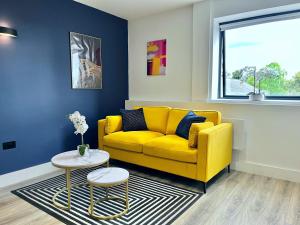a living room with a yellow couch and a table at Luxury Norwich City Centre Apartment - Free Parking in Norwich +16 photos