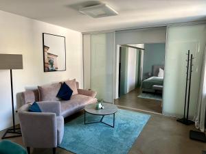 a living room with a couch and a table and a bed at Rotmain Apartments in Bayreuth