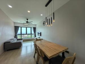 a living room with a wooden table and a couch at Meritus Relax Holiday Homestay in Perai