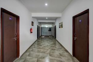 un couloir vide avec deux portes et un sol en difficulté dans l'établissement Super Hotel O Omi Rooms, à Gurgaon