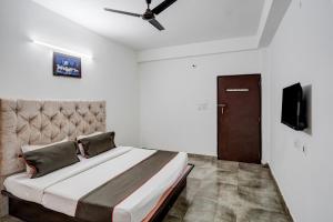 une chambre avec un lit et un ventilateur de plafond dans l'établissement Super Hotel O Omi Rooms, à Gurgaon