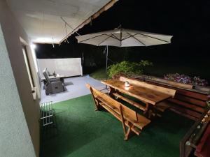 a patio with a wooden table and an umbrella at Apartment Magnolia in Blejska Dobrava +21 photos