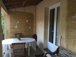 a porch with a white table and a window at La maison de caroline in Marcheprime