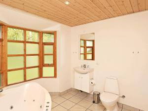 a bathroom with a tub and a toilet and a sink at 8 person holiday home in Læsø in Læsø +25 photos