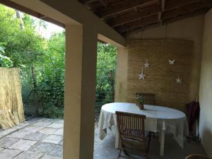 a table on the back porch of a house at La maison de caroline in Marcheprime