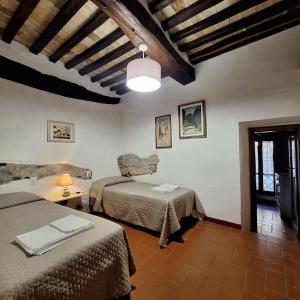 a room with two beds and a table with a lamp at casa vacanze nel Chianti il Granaio in Castellina in Chianti