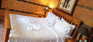 a bedroom with a bed with white sheets and pillows at Hiddengem-Luxy-v enterprises PTY LTD in Gaborone