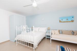 a white bedroom with a bed and a couch at Villa Lena in Stelida