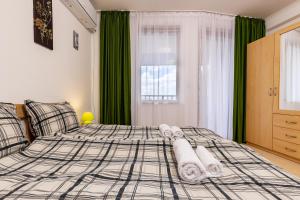 ein Schlafzimmer mit einem Bett mit Handtüchern darauf in der Unterkunft Yanevi Apartments at Grand Monastery Pamporovo in Pamporowo + 31 Fotos