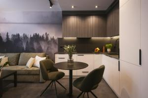 a kitchen and living room with a table and a couch at NG Apartments in Rzeszów